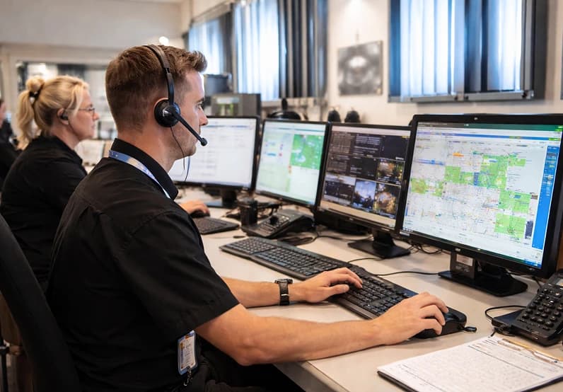 Station staff assisting passengers on the concourse during the evening peak.